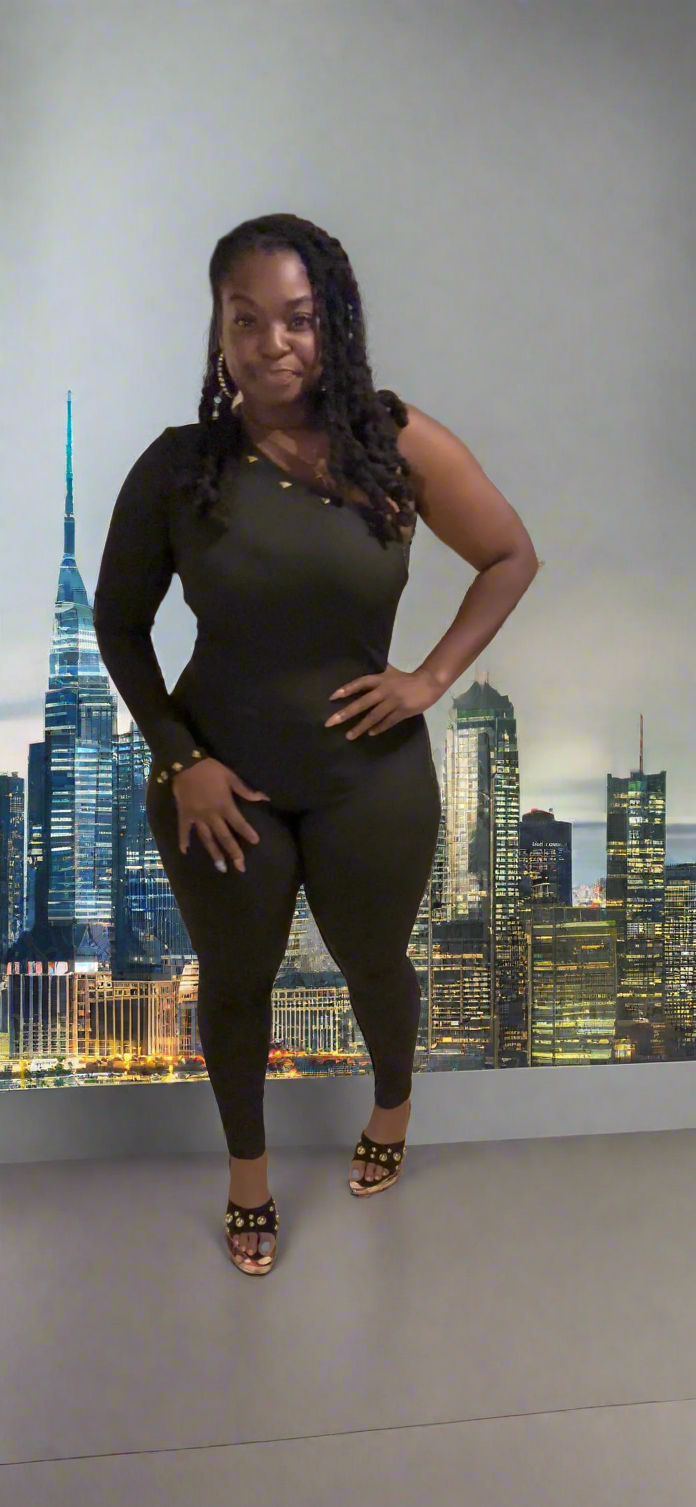 Woman wearing a black outfit standing in a room with a cityscape wall mural.