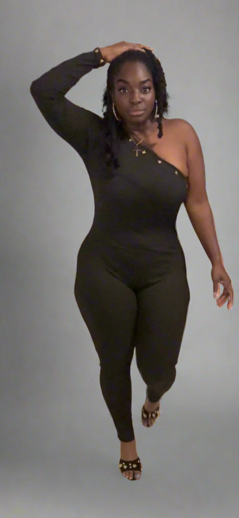 Woman in a black outfit standing in a room with a cityscape poster on the wall.